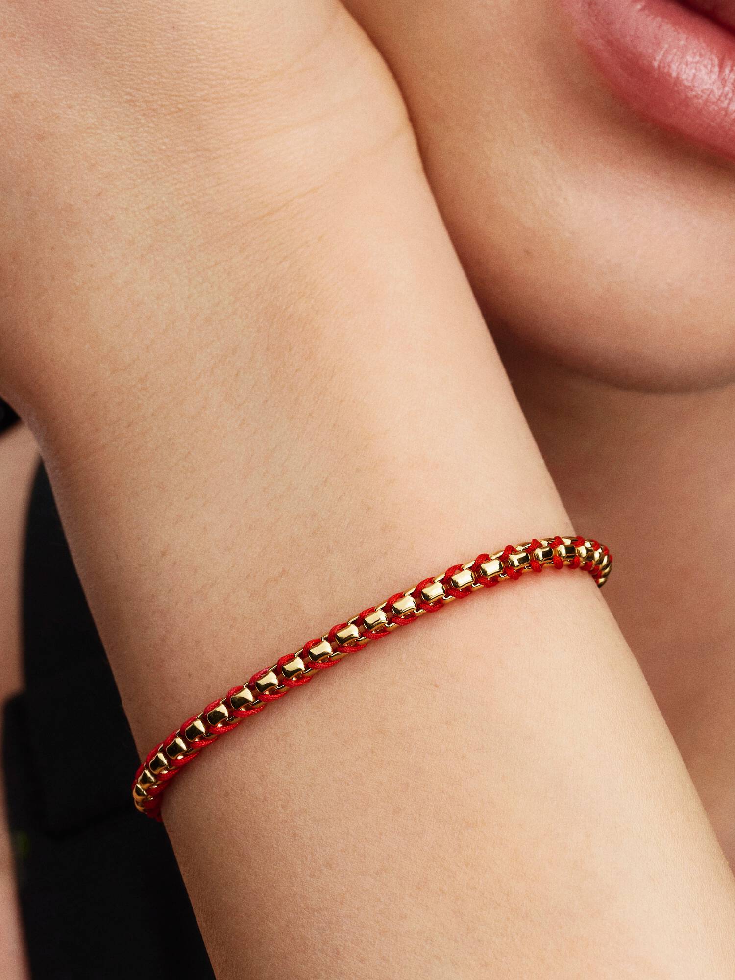 Flätat armband med röd tygdetalj