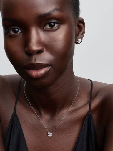 Glittrande halsband och hängsmycke med fyrklöver