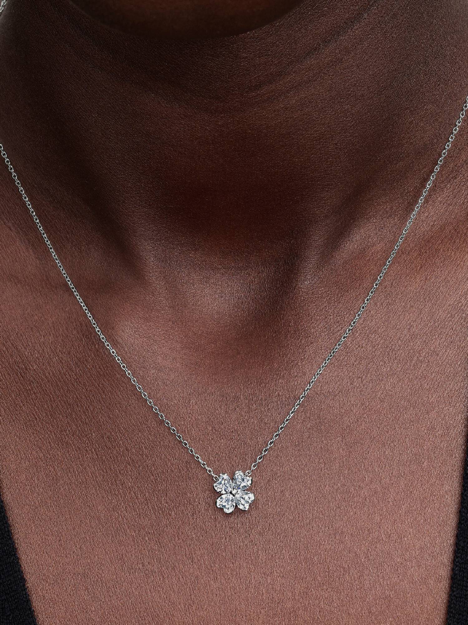Glittrande halsband och hängsmycke med fyrklöver