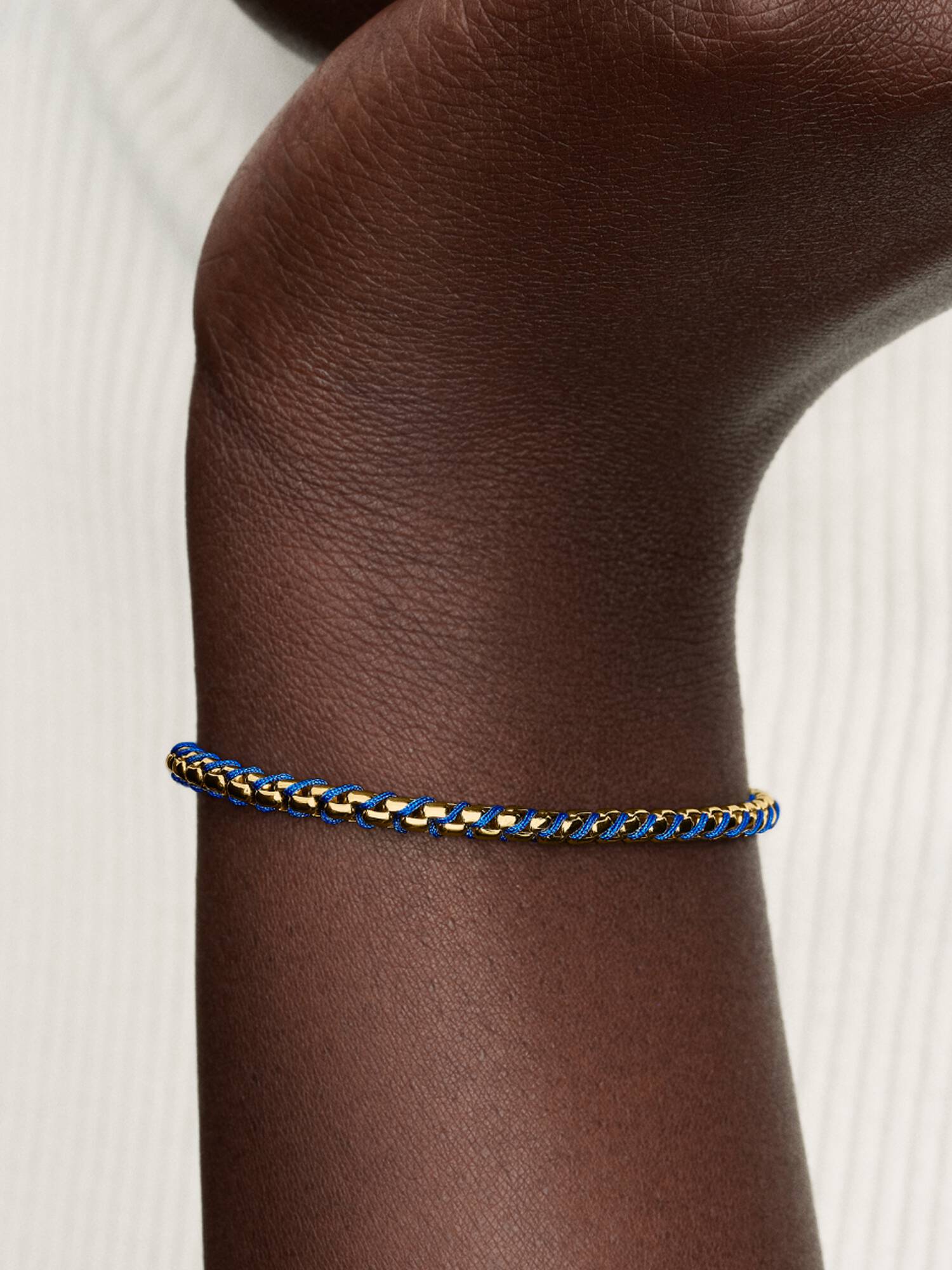 Flätat armband med blå tygdetalj 