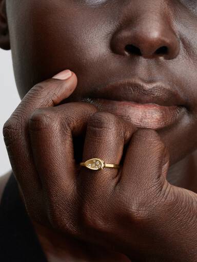 Liten guldpläterad ring med stenar